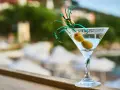 Idealny drink na wakacje: schłodzone martini z dwiema oliwkami, ozdobione zieloną wstążką. Idealne co do martini.