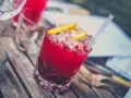 Czerwony drink z lodem i cytryną, z pewnością z dodatkiem grenadyny. Co to jest grenadyna? To syrop z granatów, idealny do koktajli.