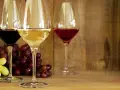 Trzy kieliszki z winem: czerwonym, białym i różowym, obok kiście winogron. Idealne na prosty przepis na wino.