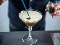 Barman dodaje ziarna kawy do drinka z pianką, idealny likier 43 zamiennik.