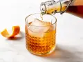 Likier amaretto z czym pić? Bursztynowy trunek z lodem i skórką pomarańczy, idealny do drinków.