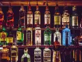 Półki pełne alkoholi, w tym butelki z napisem "The Macallan" i "The Glenlivet", sugerujące najlepsza polska whisky.