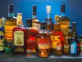 Butelki whisky i rumu. Zastanawiasz się, ile kalorii ma drink whisky z colą?
