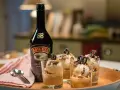 Butelka Baileys i cztery pucharki z lodami i czekoladowymi ozdobami. Idealny deser, by sprawdzić, baileys co to za smak!