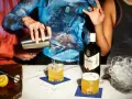 Przygotowanie drinków: whisky z syropem klonowym, cytryny i shaker na blacie.