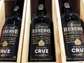 Trzy butelki półwytrawne wino portugalskie Porto Cruz Special Reserve w drewnianych skrzynkach.