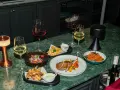 Elegancka kolacja z daniami i winem. Czy to chardonnay, jakie to wino? Obok kieliszki z białym i czerwonym winem, mięso, frytki i sałatka.