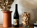 Butelka wina z etykietą Mona Lisy, obok wazonu z korkami i suszonymi kwiatami. Czy to najlepsze polskie wino?