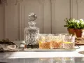 Elegancka karafka i szklanki z drinkami, idealne do serwowania bourbonu. Z czym pić bourbon? Z lodem i cytryną, jak na zdjęciu.