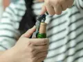 Ręce otwierają butelkę wina korkociągiem. Dowiedz się, jak otworzyć wino bez korkociągu, gdy go zabraknie.