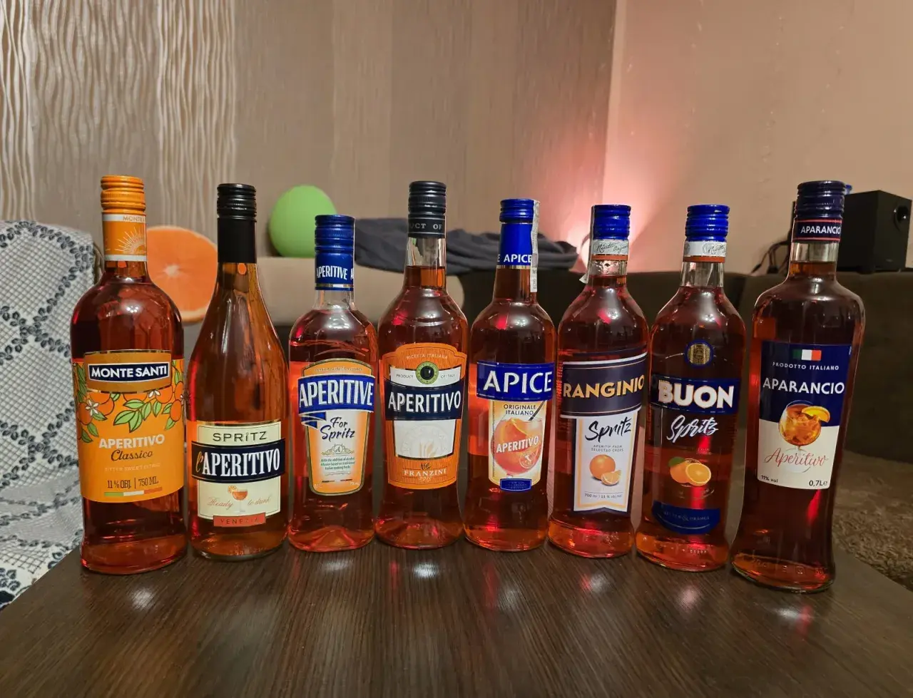 Rząd butelek aperitifów: Monte Santi, L'Aperitivo, Aperitive, Aperitivo Franzini, Apice, Ranginio, Buon, Aparancio. Idealne na drinki, jak Campari czy Aperol.