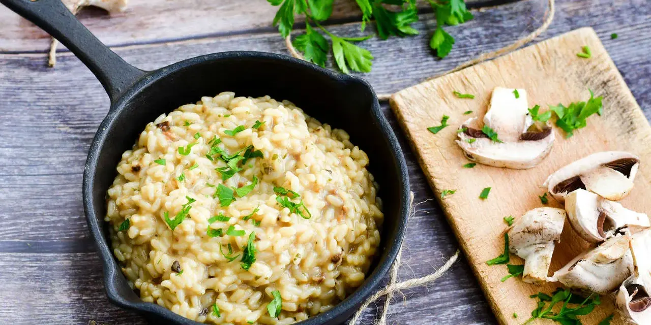 Kremowe risotto z grzybami, posypane natką pietruszki. Idealne, gdy szukasz czegoś co zamiast wina do risotto.