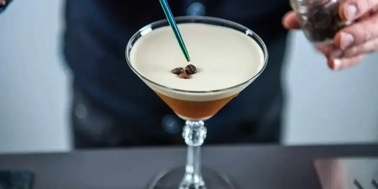 Barman dodaje ziarna kawy do drinka z pianką, idealny likier 43 zamiennik.