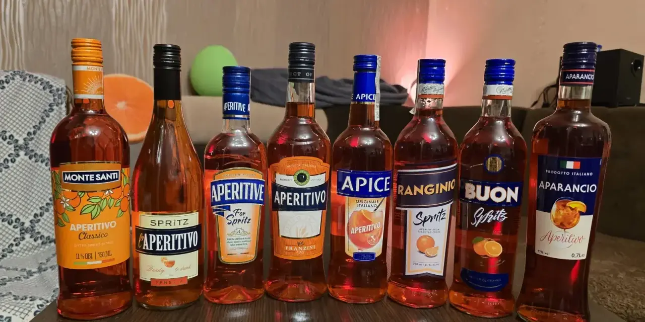 Rząd butelek aperitifów: Monte Santi, L'Aperitivo, Aperitive, Aperitivo Franzini, Apice, Ranginio, Buon, Aparancio. Idealne na drinki, jak Campari czy Aperol.