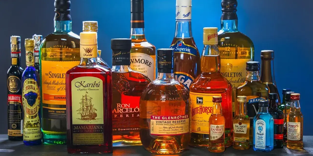 Butelki whisky i rumu. Zastanawiasz się, ile kalorii ma drink whisky z colą?