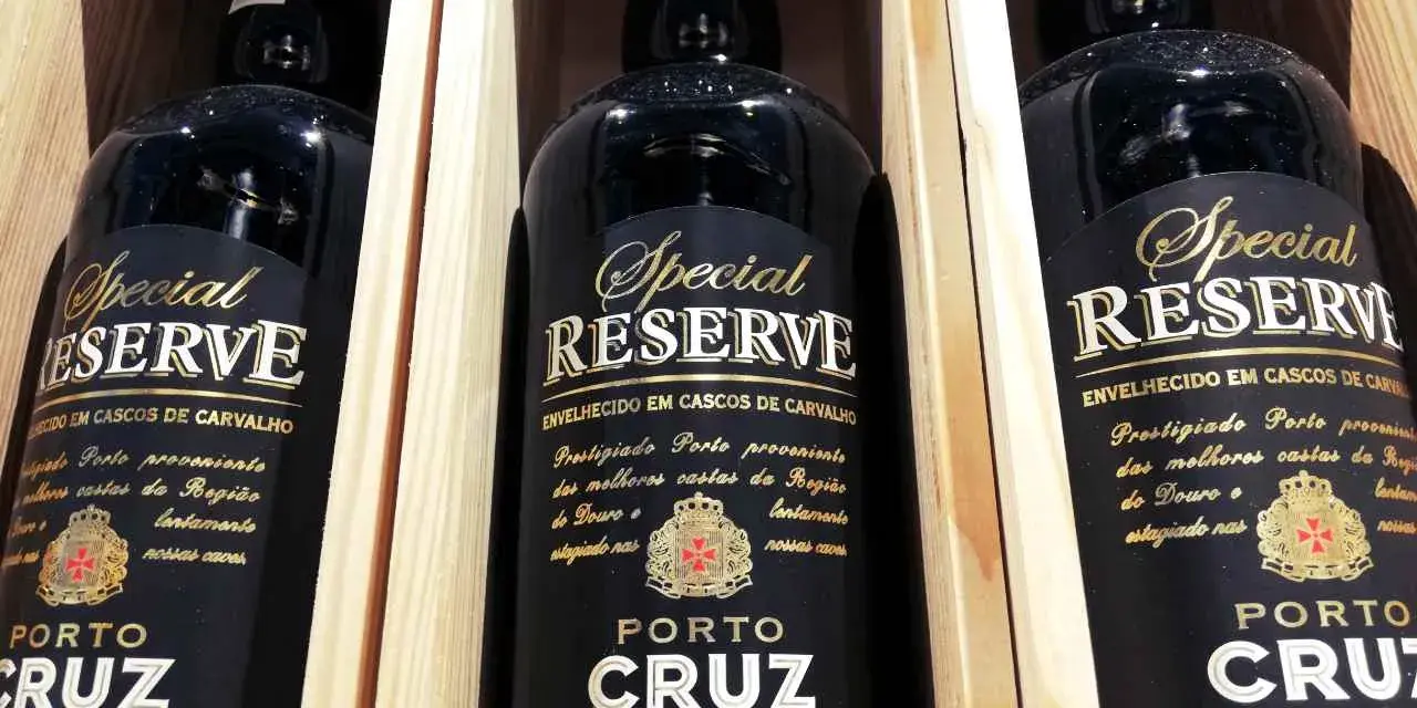 Trzy butelki półwytrawne wino portugalskie Porto Cruz Special Reserve w drewnianych skrzynkach.