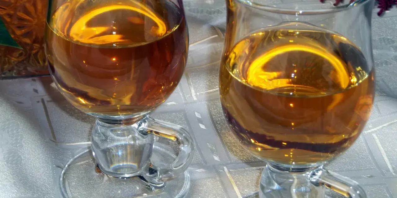 Dwa kieliszki z bursztynowym winem z ryżu i rodzynek, gotowe do degustacji.