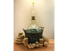 Wielka butla z rurką fermentacyjną i korkami, gotowa do tego, jak pobudzić wino do fermentacji.