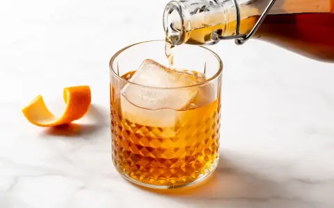 Likier amaretto z czym pić? Bursztynowy trunek z lodem i skórką pomarańczy, idealny do drinków.
