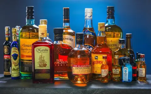 Butelki whisky i rumu. Zastanawiasz się, ile kalorii ma drink whisky z colą?