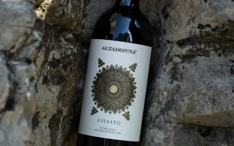 Butelka wina Altadonna Assalto Toscana, być może najdroższe wino w Polsce, spoczywa wśród kamieni.