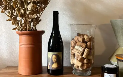 Butelka wina z etykietą Mona Lisy, obok wazonu z korkami i suszonymi kwiatami. Czy to najlepsze polskie wino?