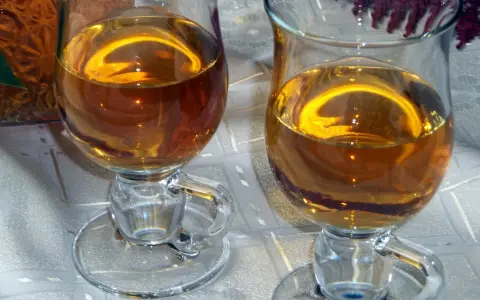 Dwa kieliszki z bursztynowym winem z ryżu i rodzynek, gotowe do degustacji.
