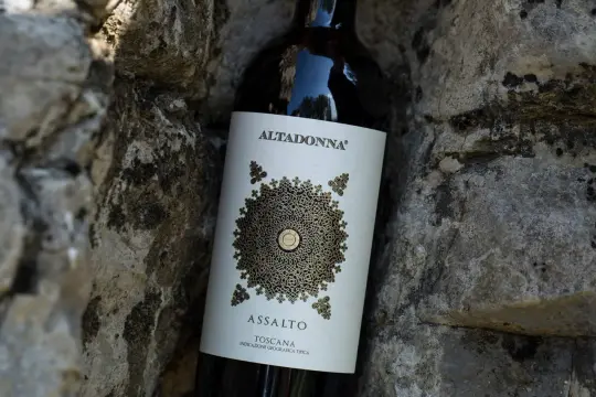Butelka wina Altadonna Assalto Toscana, być może najdroższe wino w Polsce, spoczywa wśród kamieni.
