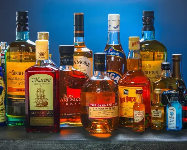 Butelki whisky i rumu. Zastanawiasz się, ile kalorii ma drink whisky z colą?