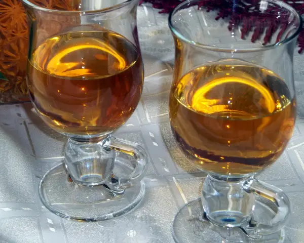 Dwa kieliszki z bursztynowym winem z ryżu i rodzynek, gotowe do degustacji.
