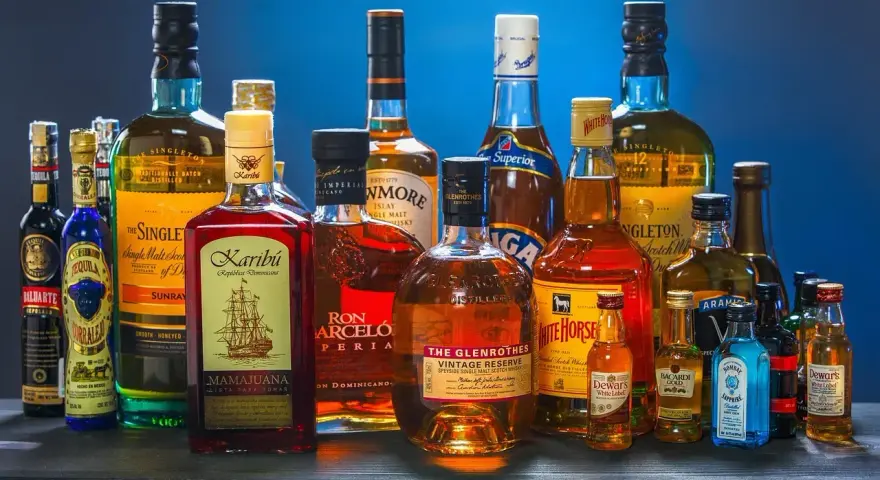 Butelki whisky i rumu. Zastanawiasz się, ile kalorii ma drink whisky z colą?