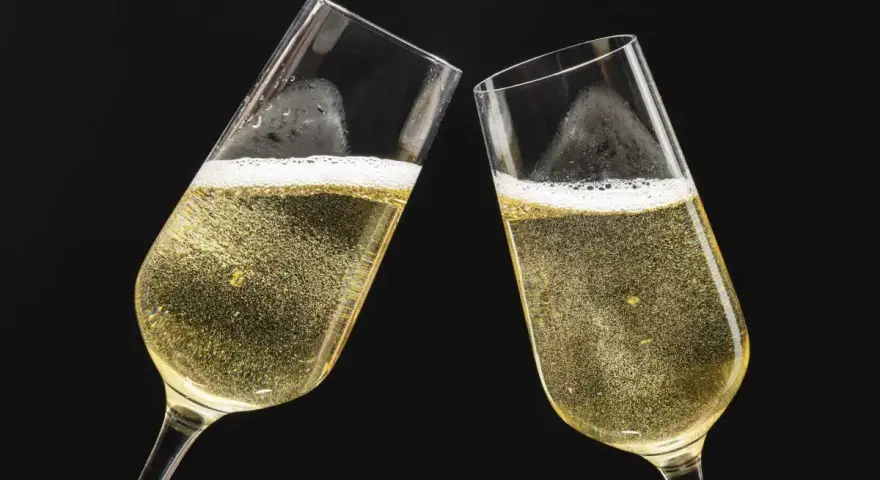 Dwa kieliszki musującego szampana, gotowe do toastu. Dowiedz się, jak otworzyć szampana, by świętować każdą okazję.