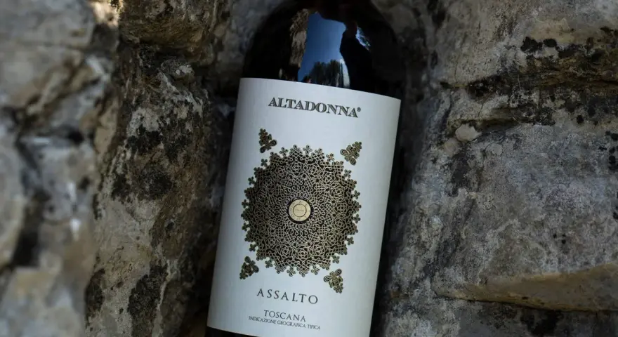 Butelka wina Altadonna Assalto Toscana, być może najdroższe wino w Polsce, spoczywa wśród kamieni.