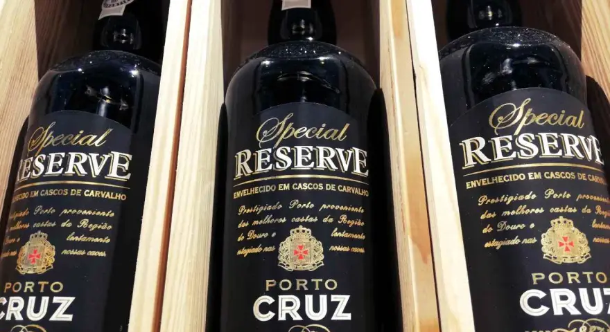 Trzy butelki półwytrawne wino portugalskie Porto Cruz Special Reserve w drewnianych skrzynkach.