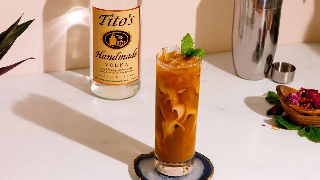 Orzeźwiający drink z lodem i miętą, obok butelka w&oacute;dki Tito's. Idealny na letnie popołudnie, smakuje jak martini ice tea.