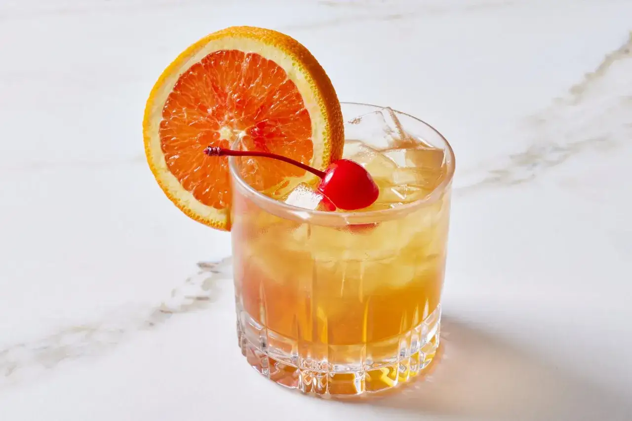 Orzeźwiający drink z amaretto, lodem, plasterkiem pomarańczy i wisienką koktajlową.