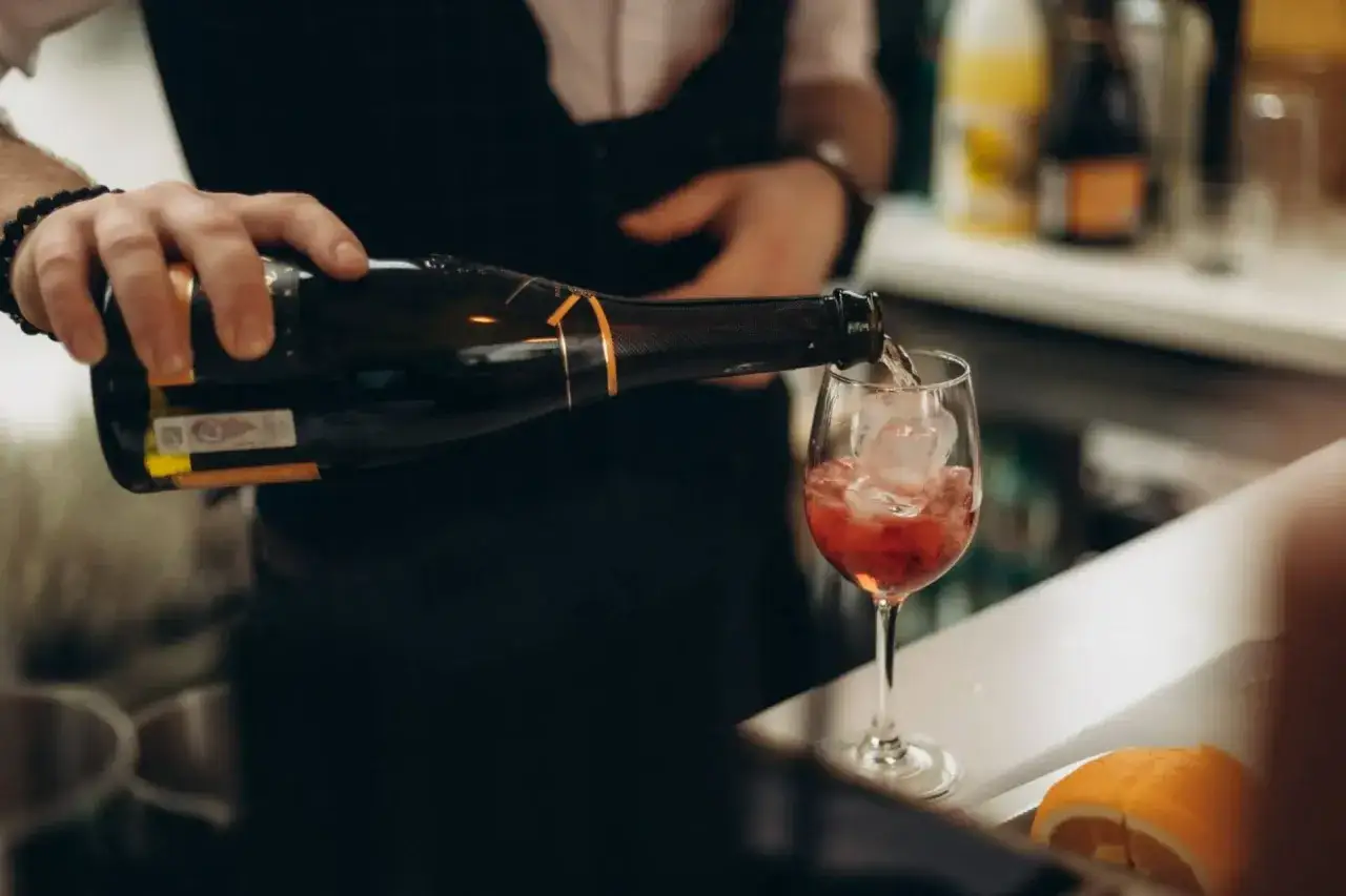 Barman nalewa prosecco do kieliszka z lodem. Idealny spos&oacute;b, jak pić prosecco latem.