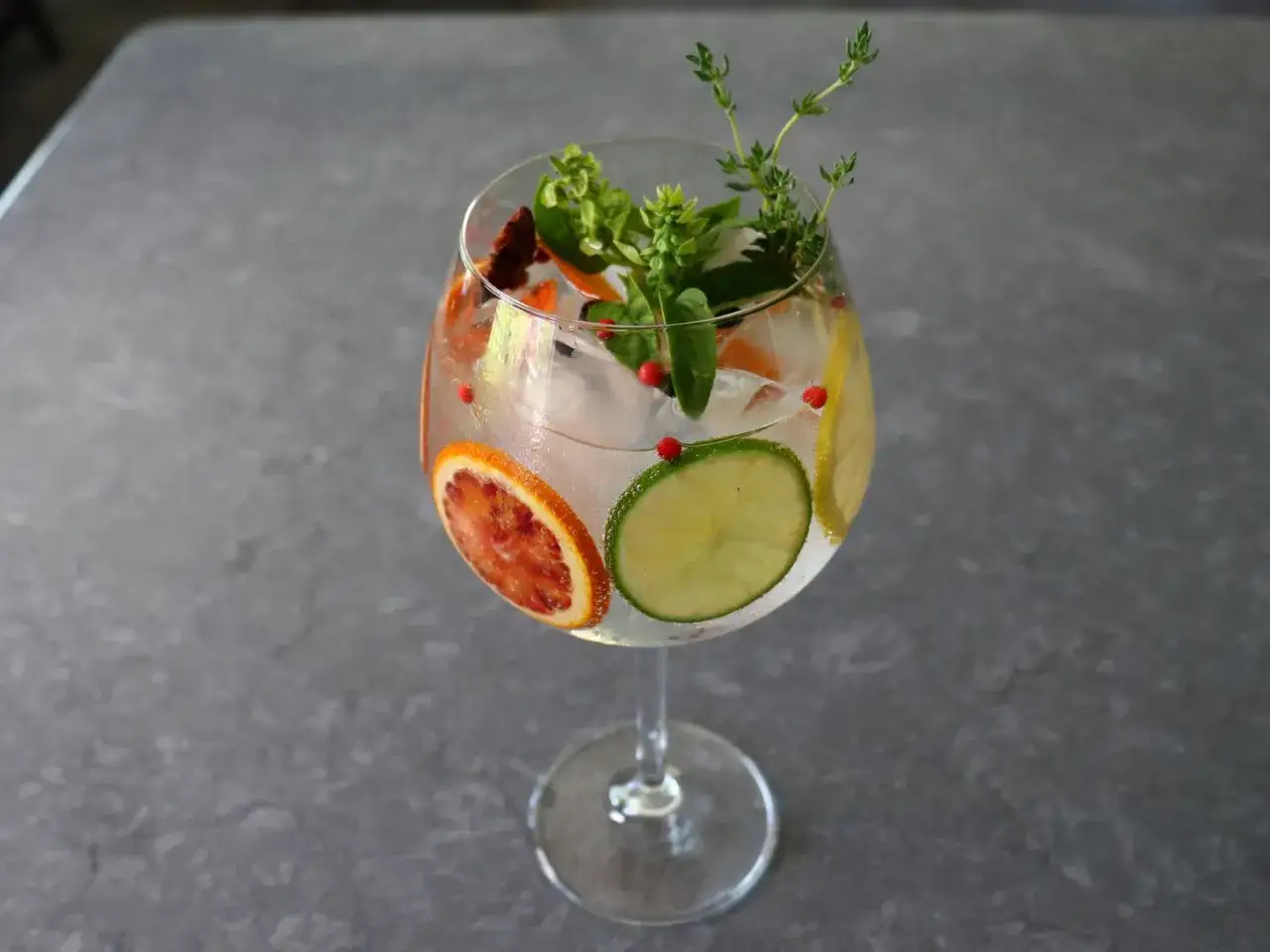 Orzeźwiający martini tonic z plasterkami cytrus&oacute;w, ziołami i r&oacute;żowym pieprzem. Idealny na letnie popołudnie.