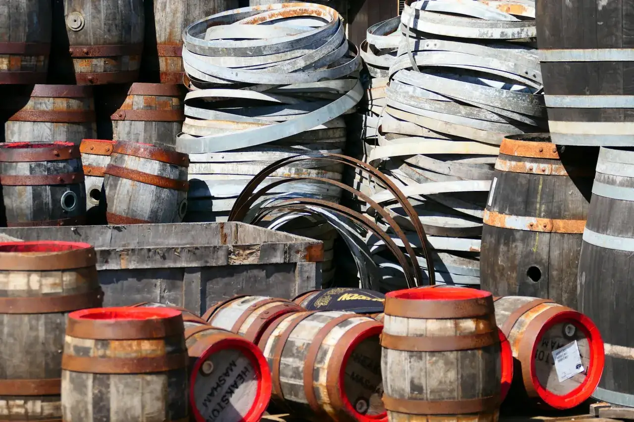 Stare beczki, gotowe na leżakowanie blended whisky. Metalowe obręcze i drewno tworzą stosy.