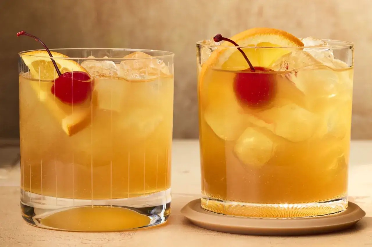 Dwa drinki z likierem amaretto, lodem, plasterkiem pomarańczy i wisienką. Idealne na letnie wieczory.